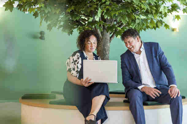 Blij medewerkers lopen door de gang dankzij performance management