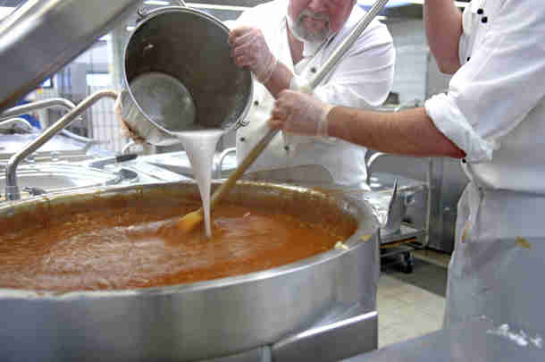 Koks roeren soep in een gaarkeuken